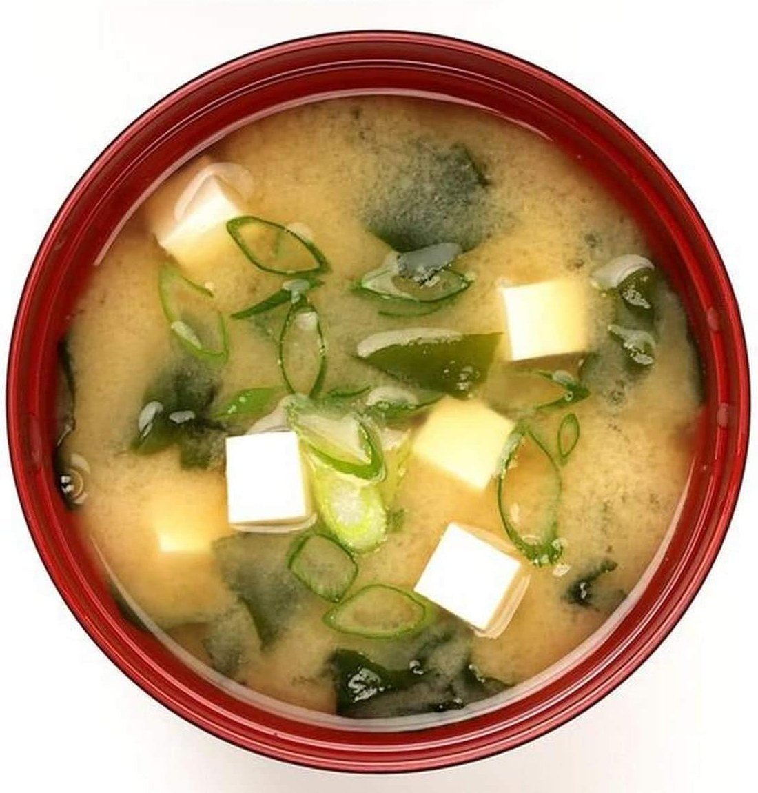 Looking down into the red inside of the miso bowl, full of miso soup
